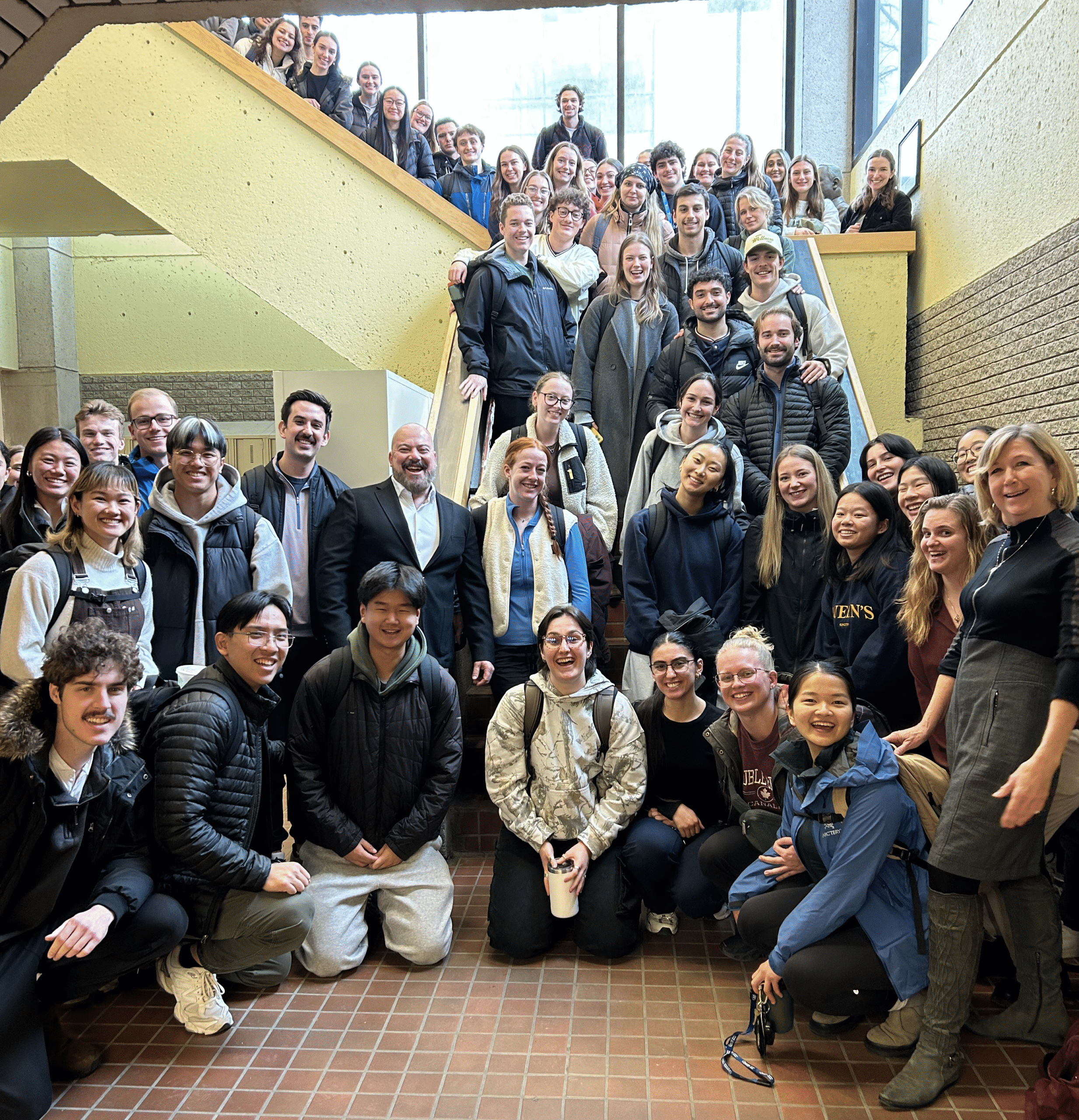 Sarah Hutchison, OPA CEO in the front right with group of Queen's University physical therapy students in a hallway and stairwell at school.