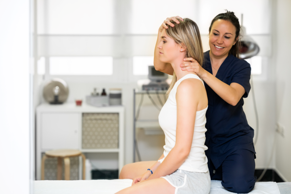 female physiotherapist examining and treating client's neck and has one hand on her neck and another on her head