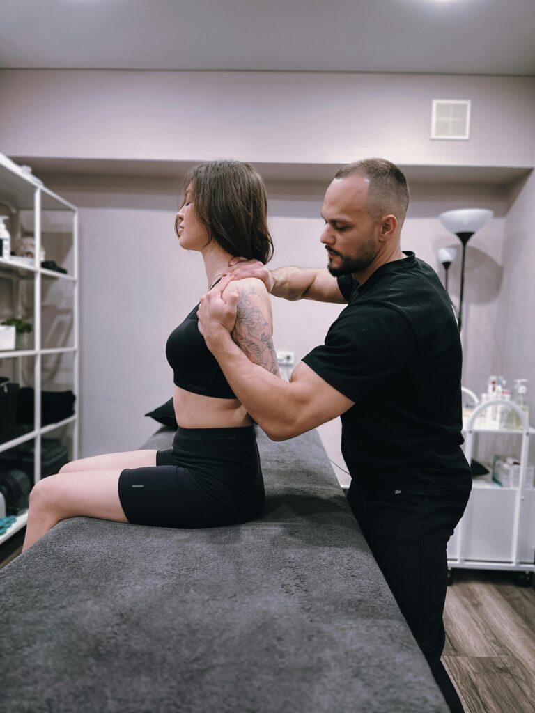 Male physiotherapist treating female client's upper body
